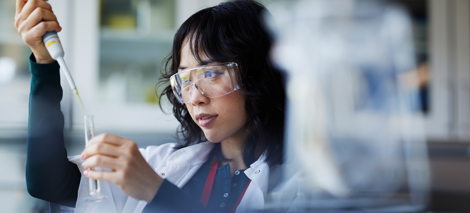 Scienziato che utilizza una pipetta per trasferire un liquido in una provetta in un laboratorio